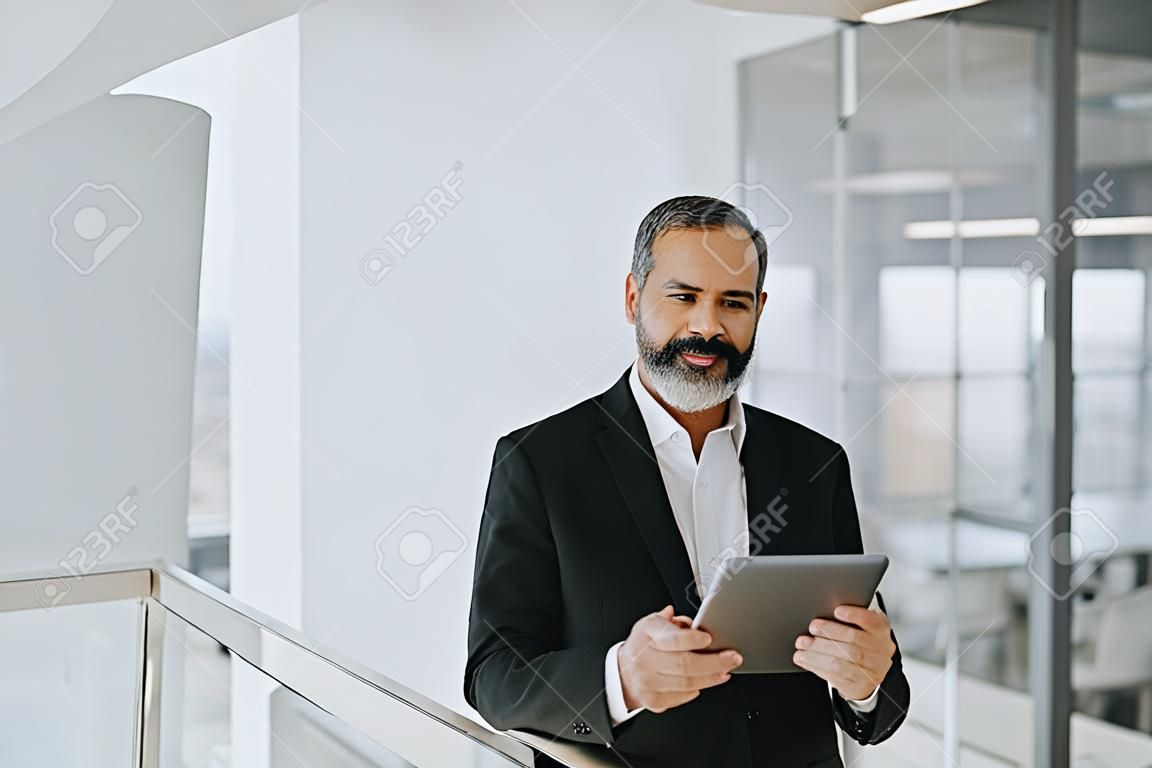 Handsome middle age businessman with digital tablet in the modren office