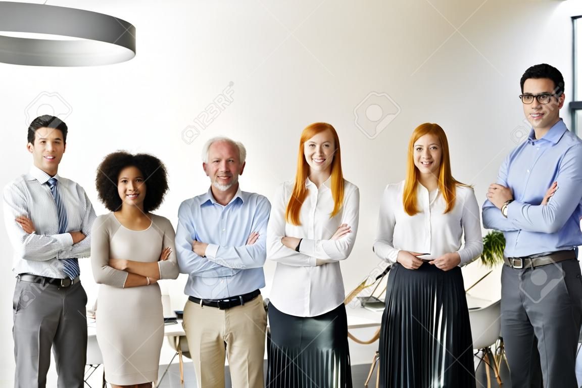 Linea di uomini d'affari felici e positivi in piedi in ufficio