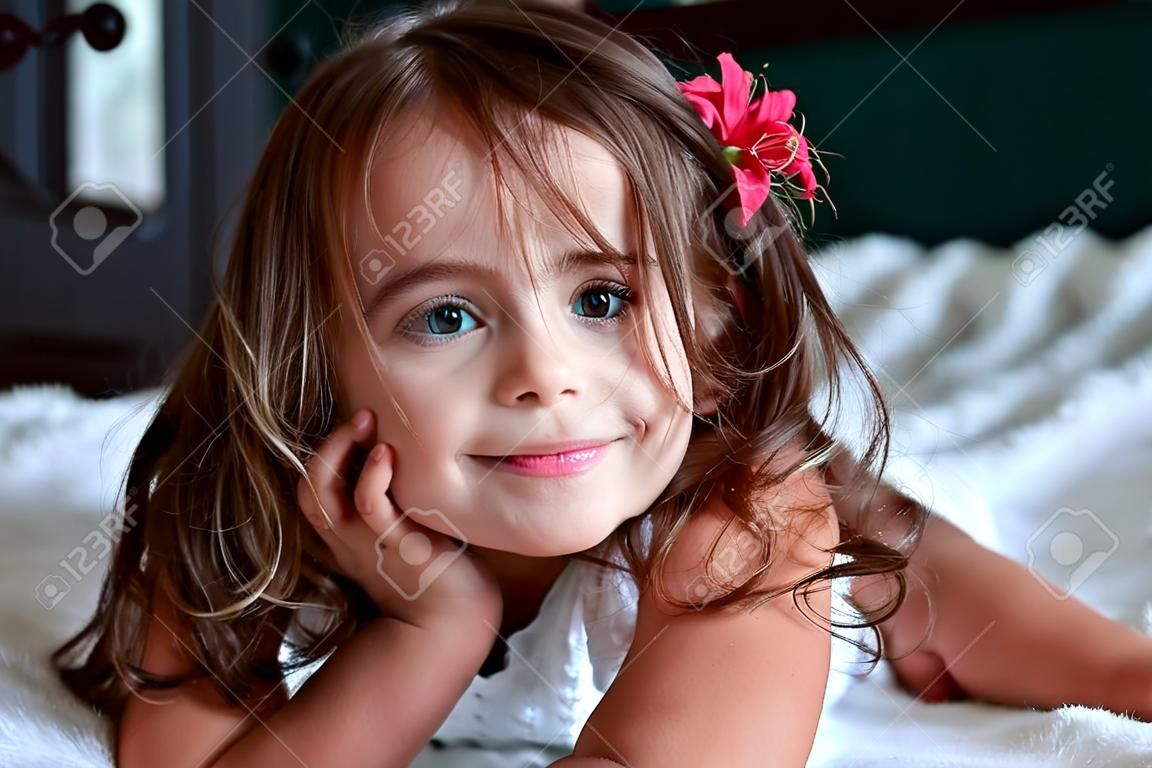 de kleine glimlach meisje met een bloem in haar haar