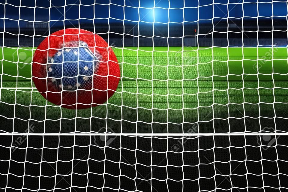 El disparo de pelota de fútbol con la bandera de Europa en la red
