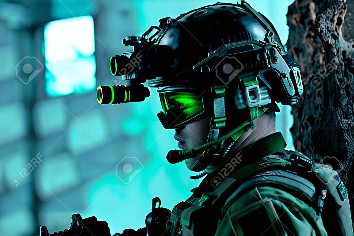 Closeup man uniform with machine gun and turned on night vision device. Airsoft soldier with green light on face in night building. Side view.