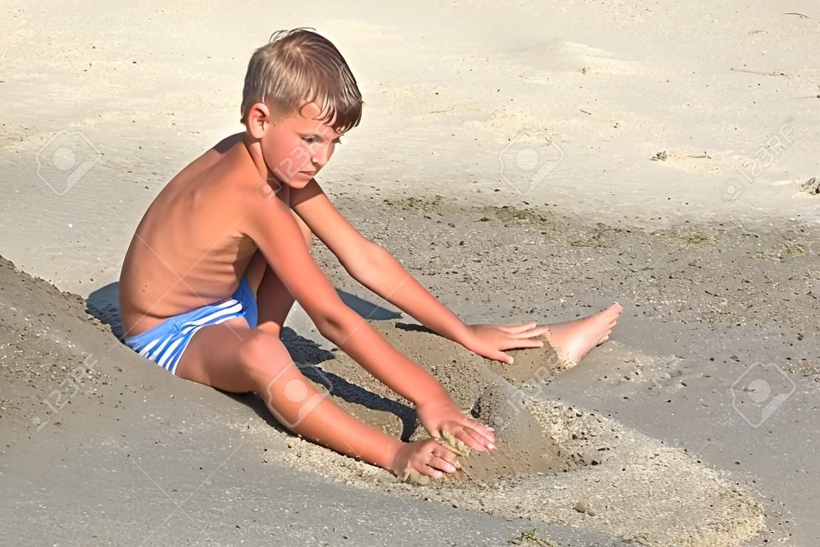 Beau Garçon De Huit Ans Sur La Plage Jouant Avec Un Jet De Sable Banque  D'Images et Photos Libres De Droits. Image 84433177