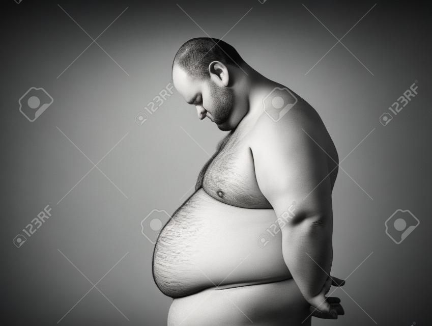 Sad fat man looking at his tummy