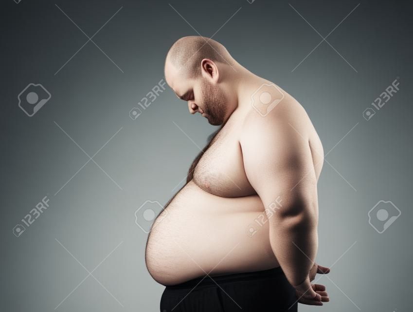 Sad fat man looking at his tummy