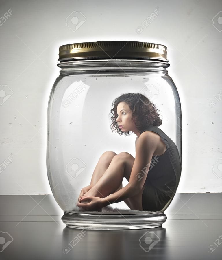 Jeune femme emprisonnée dans un bocal en verre