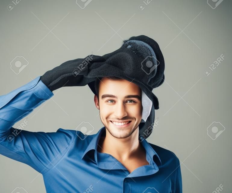 Sorrindo jovem homem tirando uma máscara