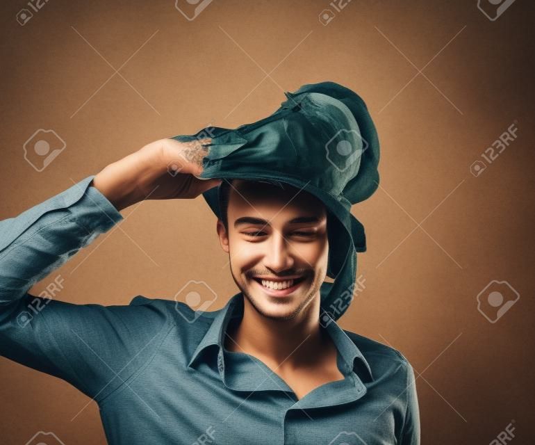 Smiling young man taking off a mask
