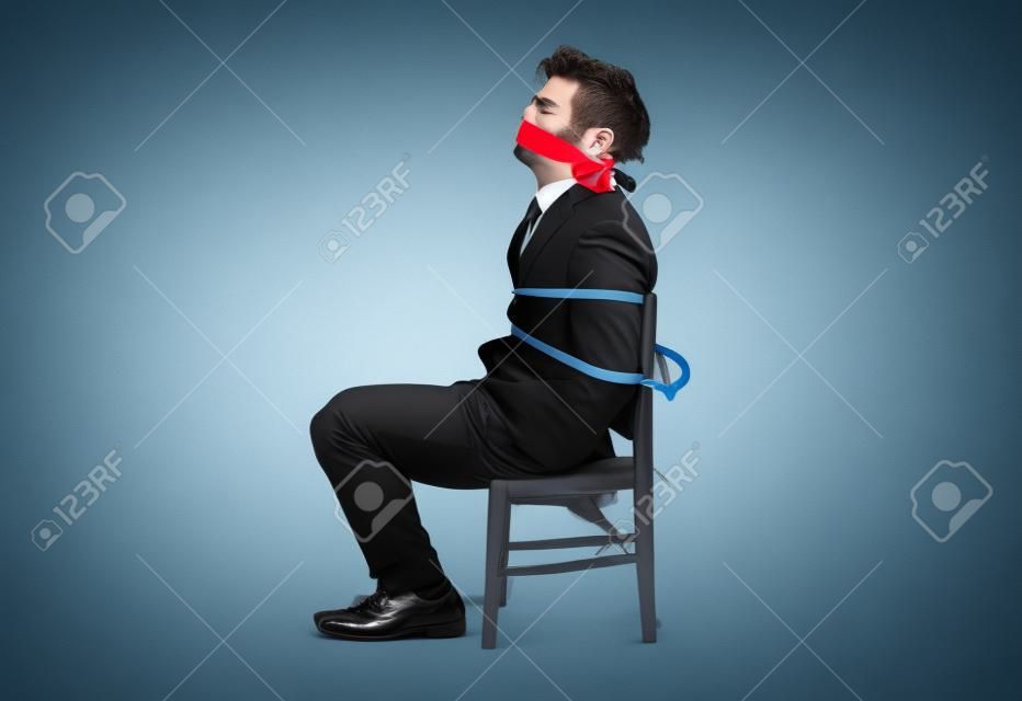 Empresário amarrado a uma cadeira e amordaçado