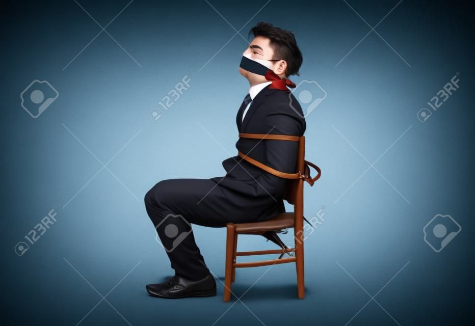 Empresário amarrado a uma cadeira e amordaçado