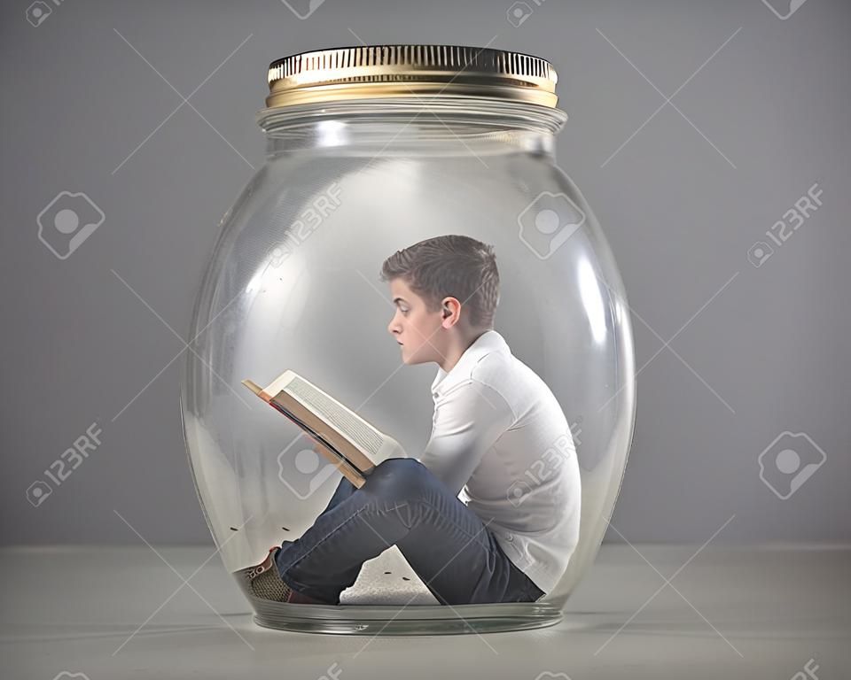 小男孩讀的書坐在罐子