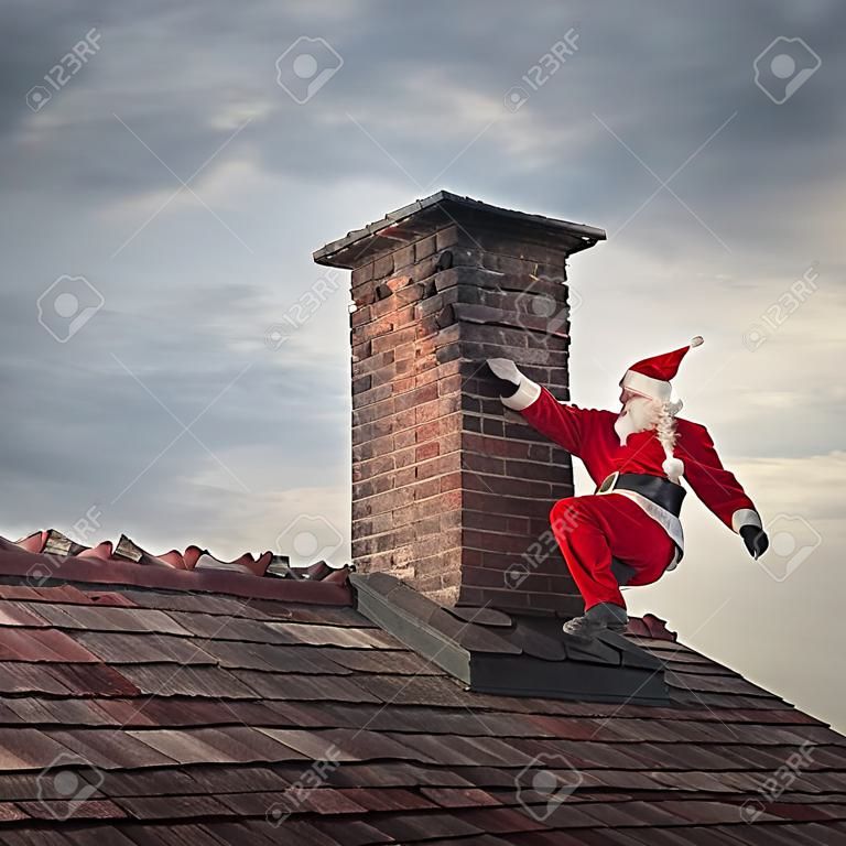 Père Noël grimpant sur une cheminée