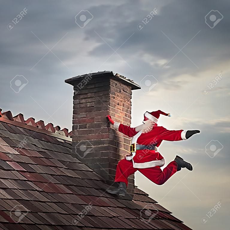 Père Noël grimpant sur une cheminée