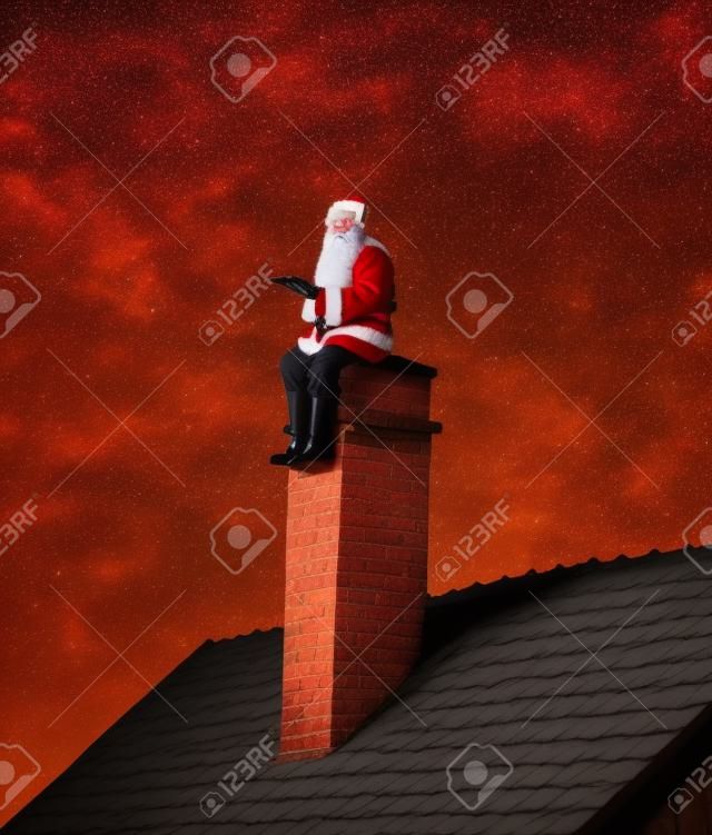 Santa que se sienta en la chimenea
