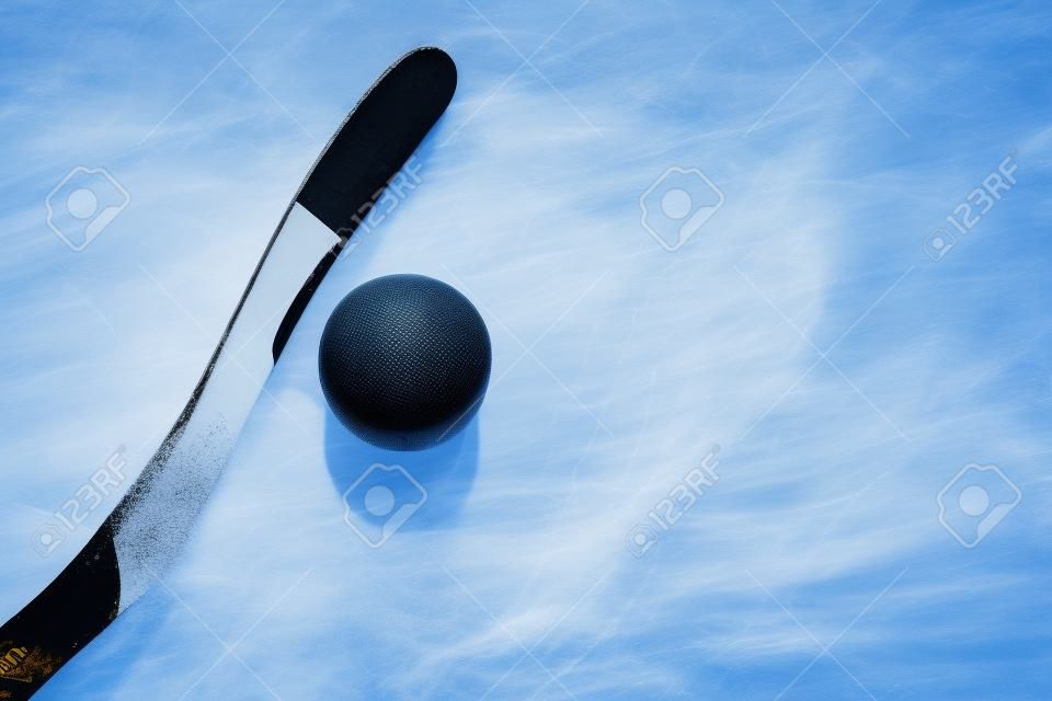 palo de hockey y el puck en el hielo