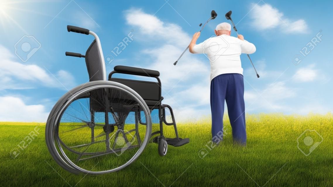 la recuperación milagro: El viejo hombre se levanta de la silla de ruedas y levanta las manos en alto. Rodada en un prado. concepto de recuperación