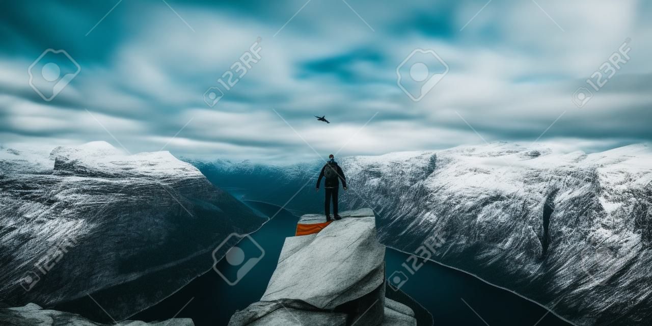 Life on the edge Traveler on cliff mountains over fjord enjoying Norway landscape Travel Lifestyle success motivation concept adventure active vacations outdoor