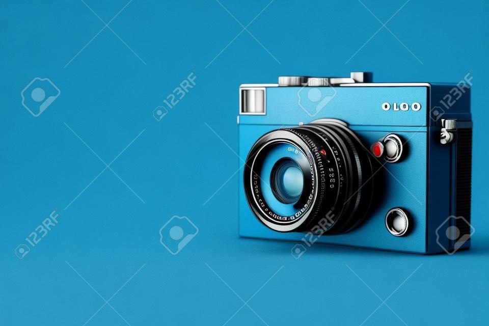 Old rangefinder vintage camera on blue background