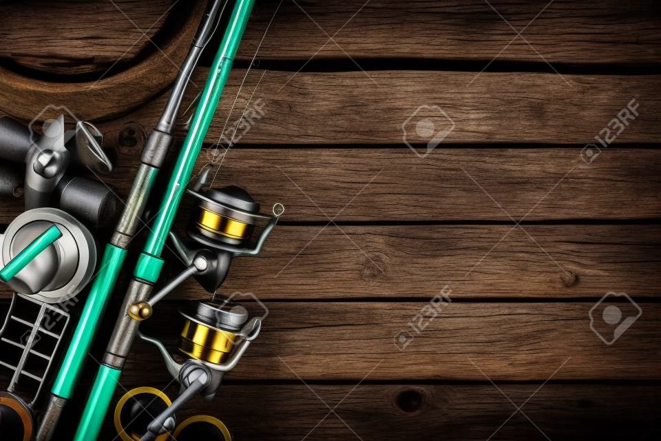 釣りフィーダーとリール。釣り道具の背景。釣りフィーダー-暗い木製の背景のフックとルアー。