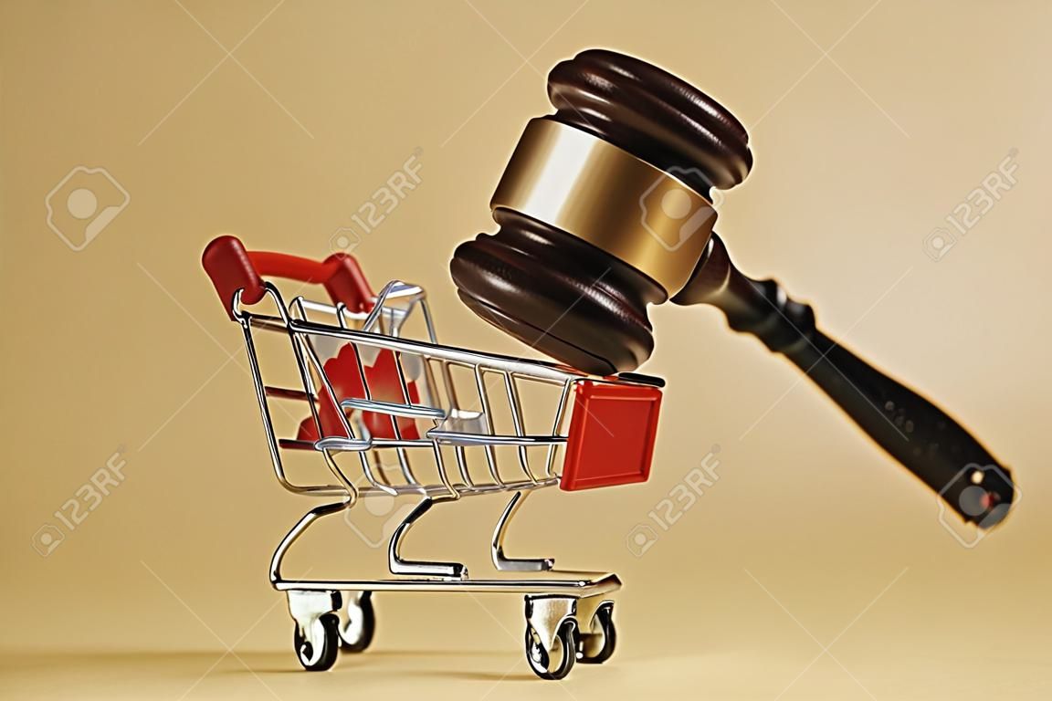 Bescherming van de rechten van de consument. Hamer van de rechter met een trolley op een witte achtergrond. Close-up