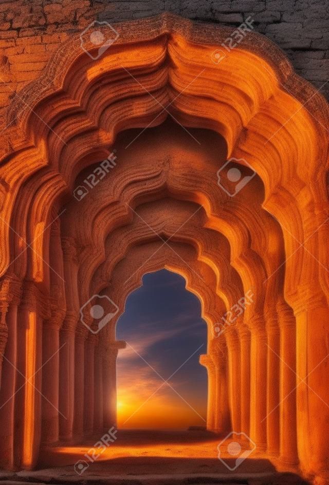 在日落在印度古代寺廟的老拱毀