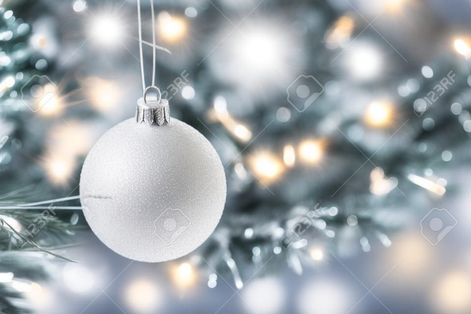 White ball on Christmas tree. Selective focus. Holiday card with decorations for the New Years Eve