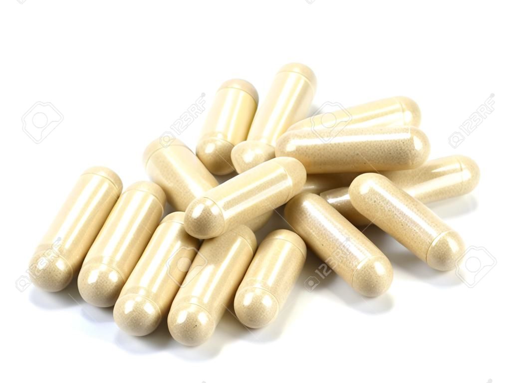 Drug capsule pills with beige medication in pile, isolated