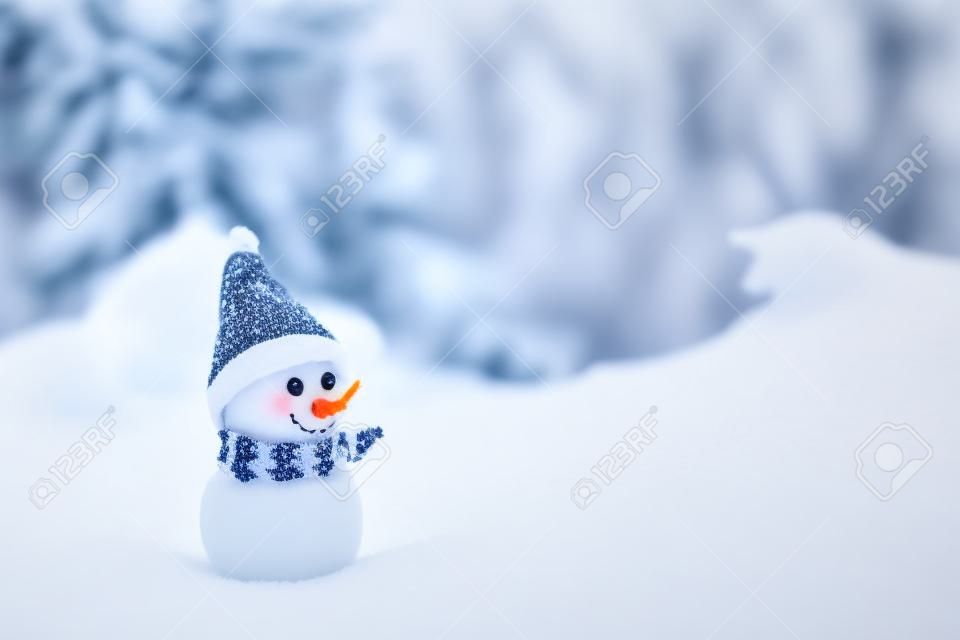 Pequeño muñeco de nieve sobre la nieve blanda en el bosque en invierno