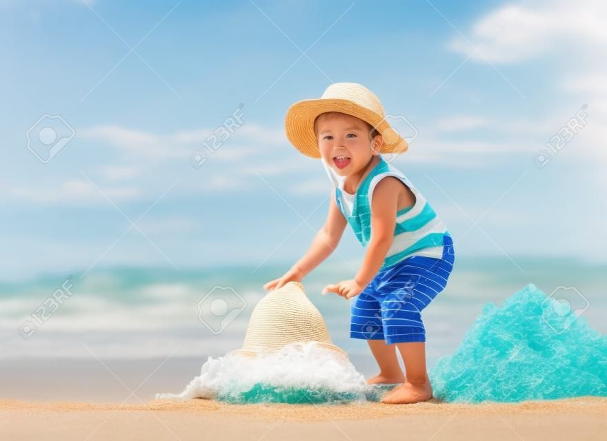 밀짚 모자에있는 해변에서 산책 어린 소년