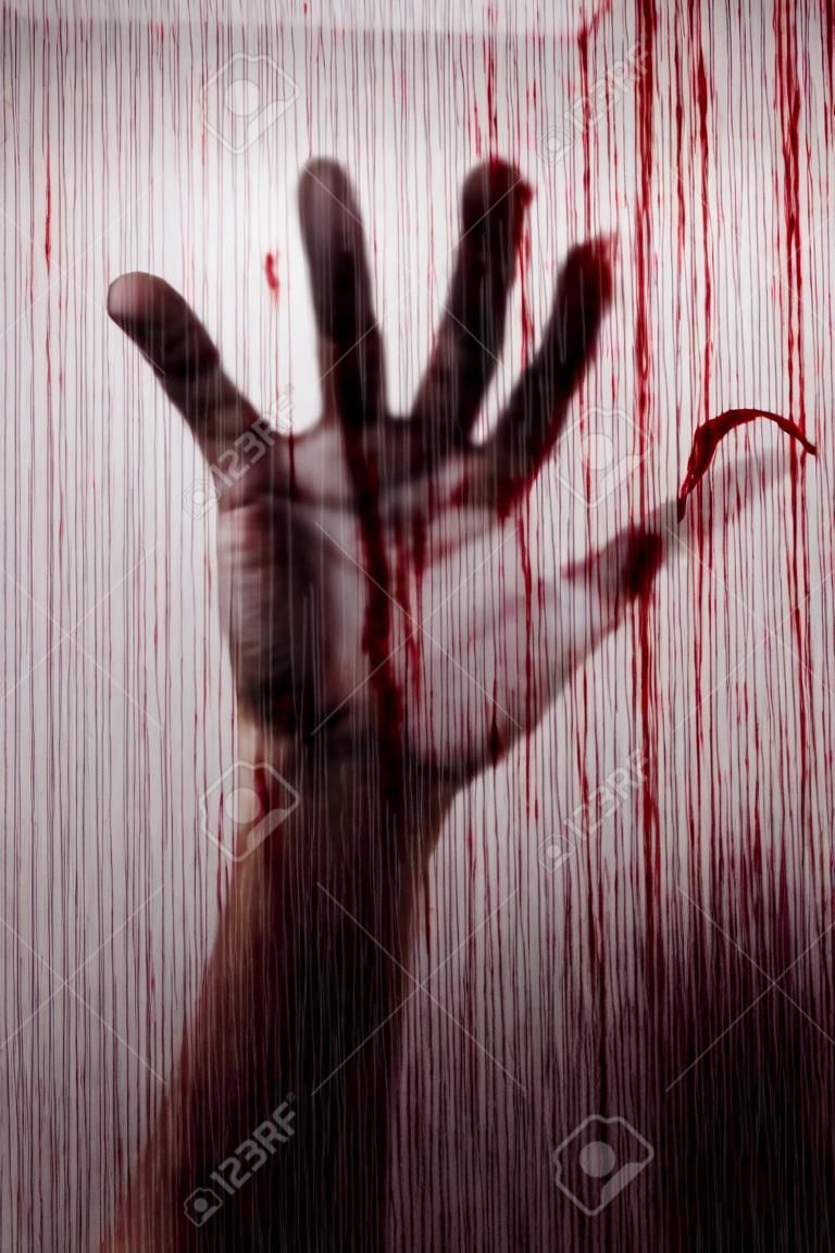 Blurry moordenaar hand achter mat glas met bloed vlekken moord concept