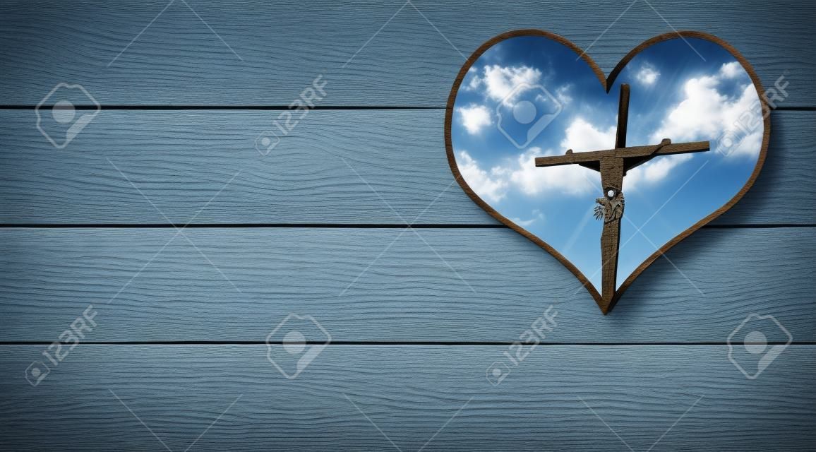 十字架のイエスとハートの形の穴と木製の壁と青い空と雲