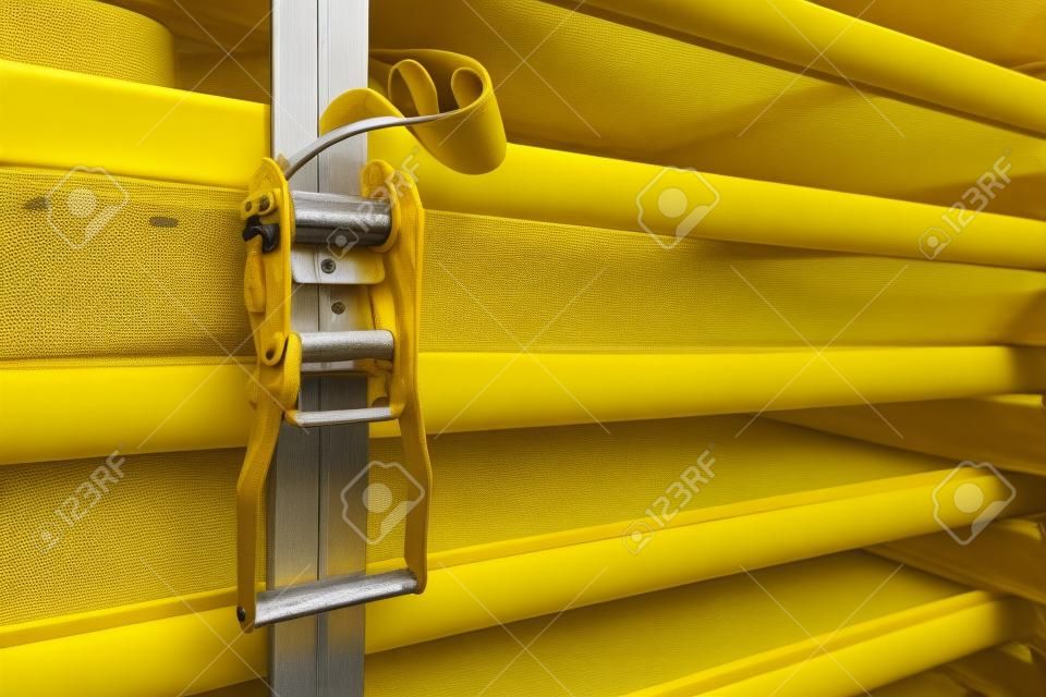 Objects fixed by yellow ratchet strap. Concepts of firm, strong, and stable.
