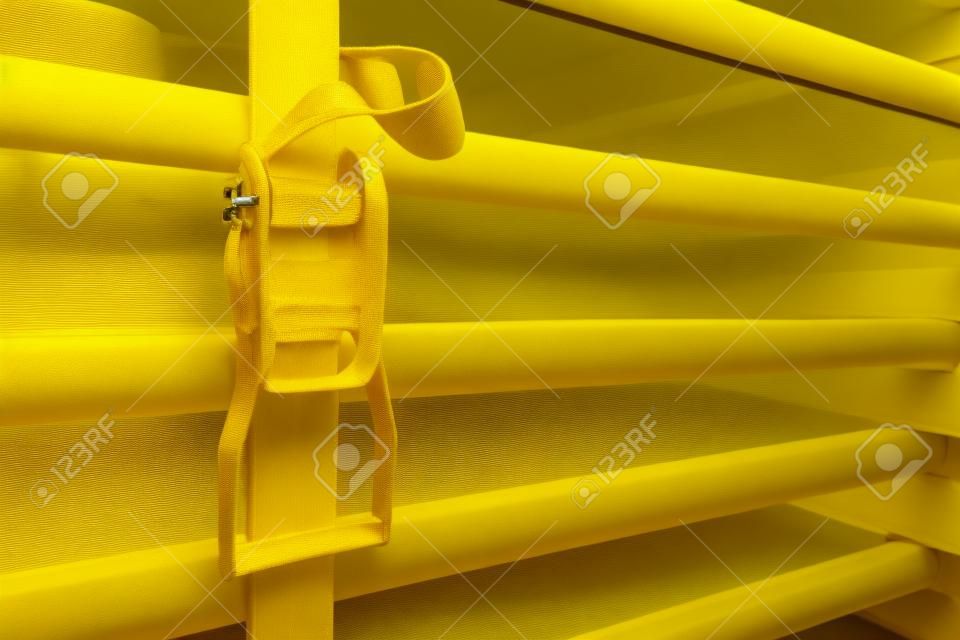 黃色棘輪皮帶固定的物體。牢固，牢固和穩定的概念。