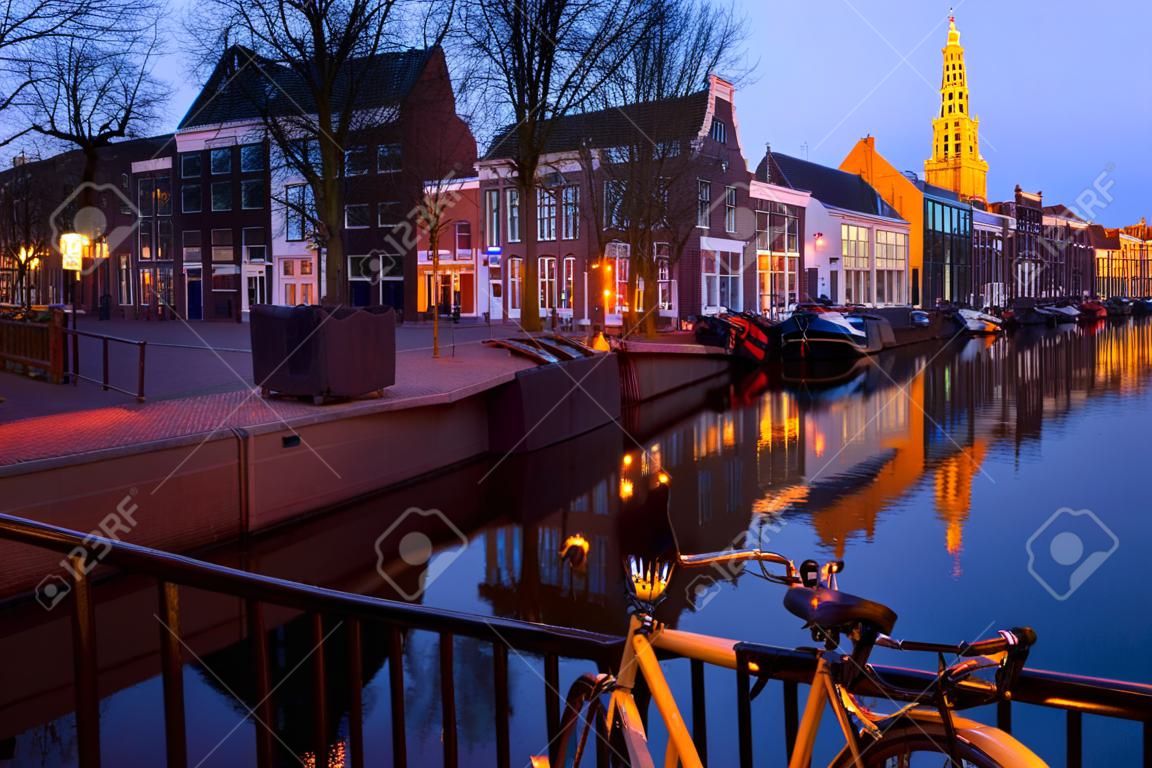 Rua holandesa com bicicletas bu canal no crepúsculo, Groningen