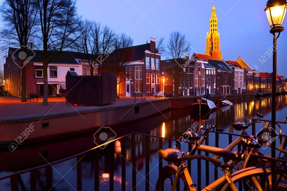 Dutch street with bicycles bu canal in dusk, Groningen