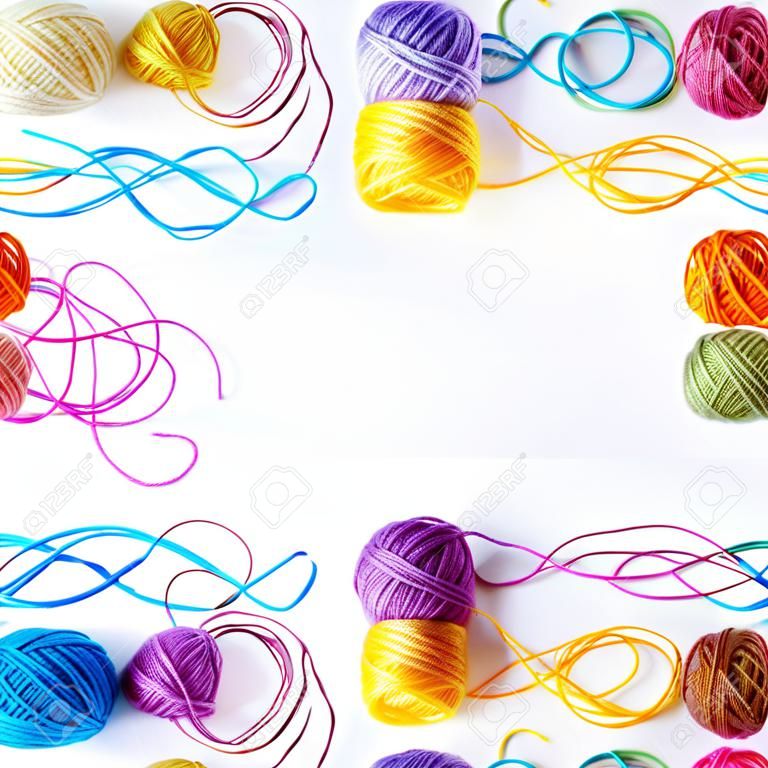 カラフルな白い背景の上の糸のコイルの編み物