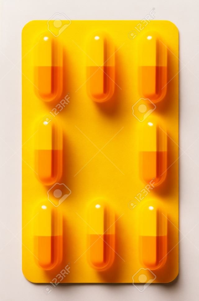 Одной таблетки желтого и красного капсулы, изолированных в белом фоне