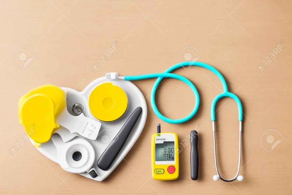 Monitorowanie cukrzycy, pomiar cukrzycy. koncepcja światowego dnia cukrzycy. żółty stetoskop sprawdzić owoce na talerzu serca.