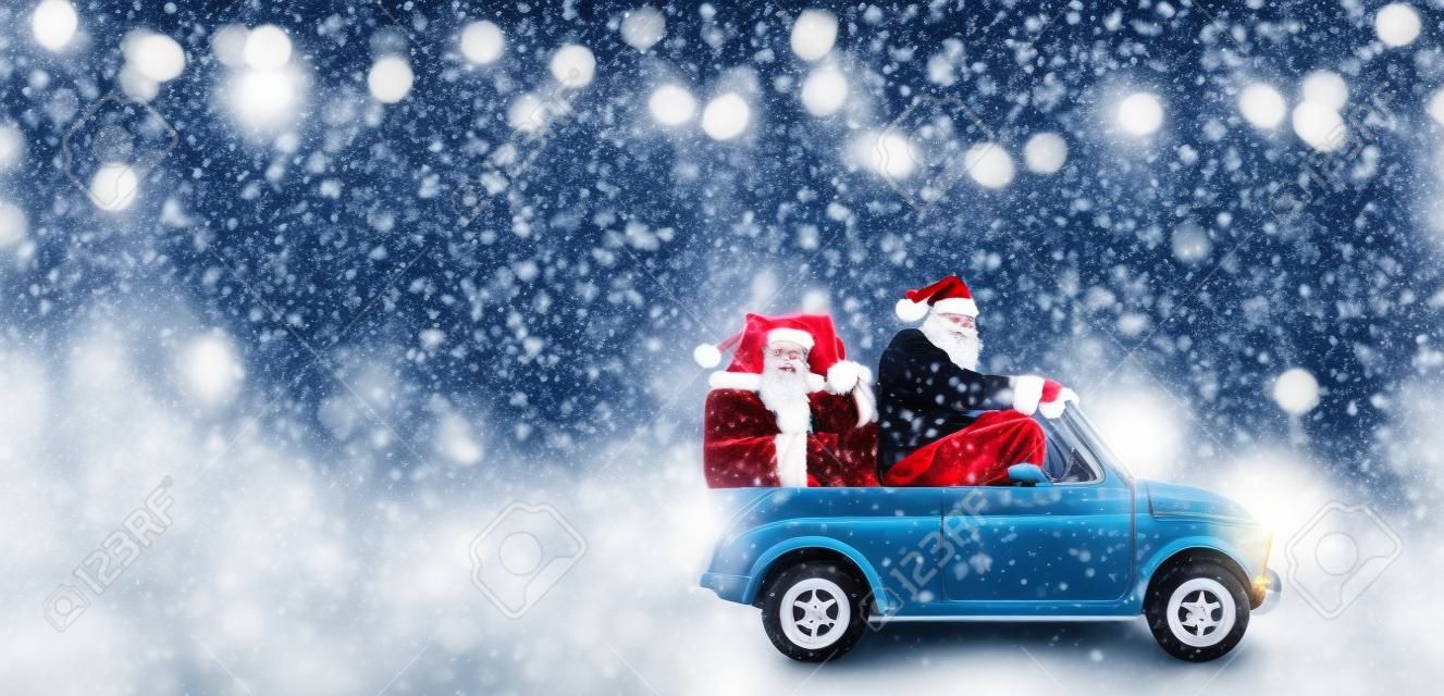 提供聖誕節或新年禮物的汽車的聖誕老人在多雪的灰色背景