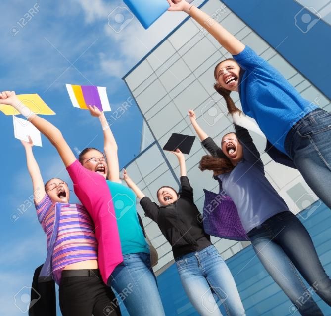 Gelukkige studenten springen van vreugde na het examen