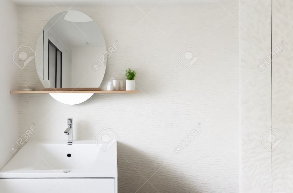 Lavandino bianco e specchio appeso sopra di loro, bancone in legno, mensola in legno, design moderno degli interni della camera da letto con pareti bianche