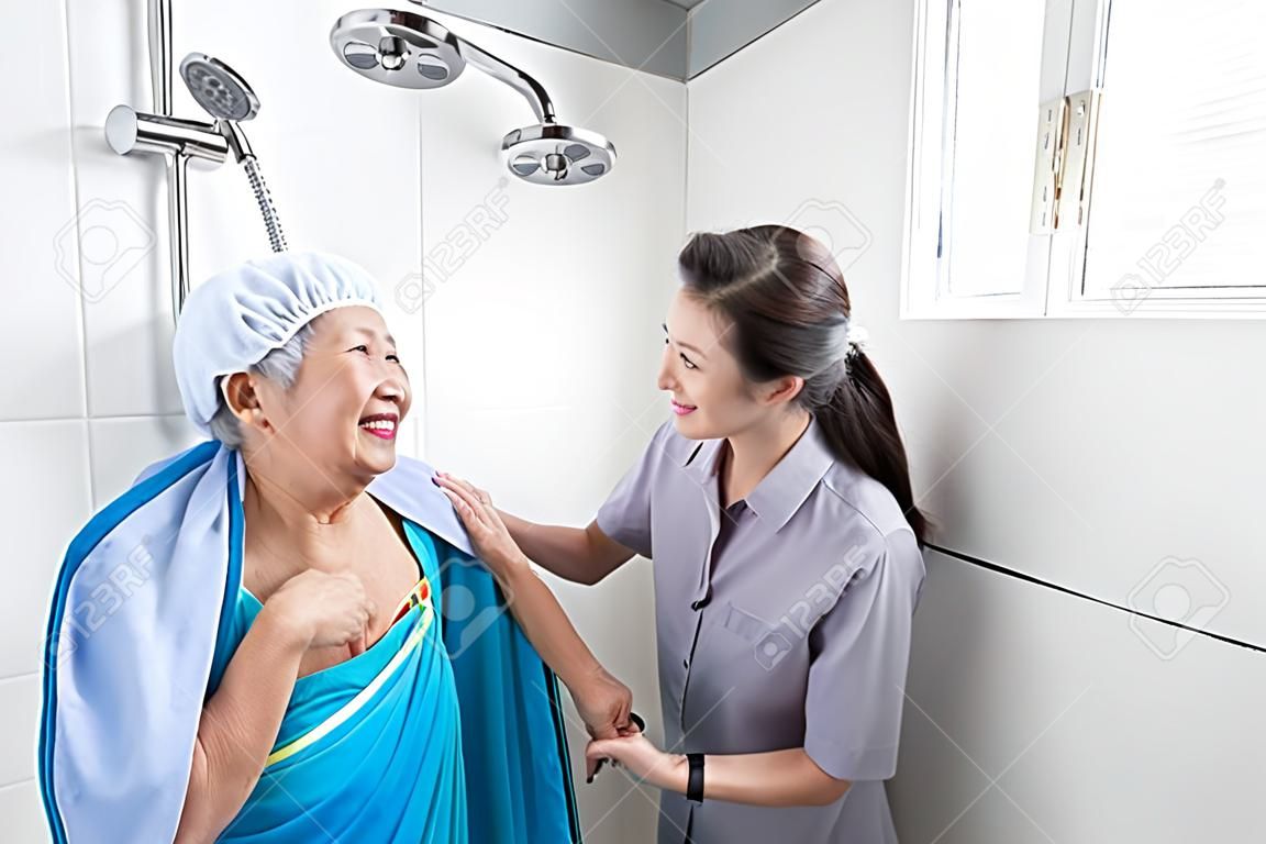 Azjatycka usługa opieki nad córką lub kobietą, pomoc, wsparcie starszej kobiety biorącej prysznic w łazience, uważaj, szczęśliwa matka jest trudna do pomocy sobie, zaniepokojona bezpieczeństwem i wypadkami osób starszych w domu
