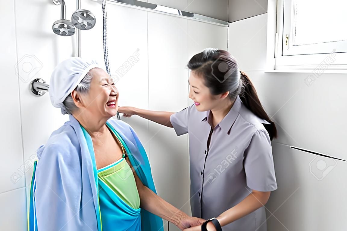 Asian daughter or female care assistant service,help,support senior woman taking a shower in bathroom,take care closely,happy mother is difficult to help herself,concerned about the safety and accidents of elderly people at home