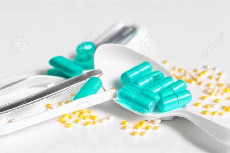 Medizinpillen, Tabletten und Kapseln auf weißem Teller für Patienten.
