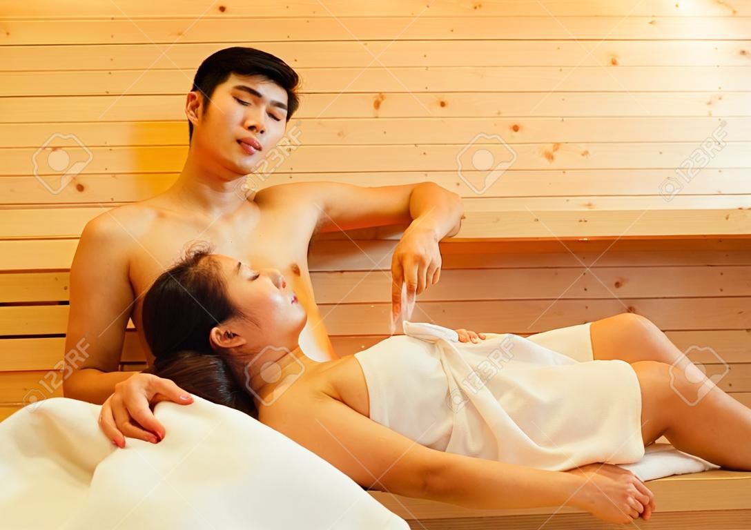 Couple at sauna spa healthy concept, Young asian man handsome and woman beautiful together sitting in room with hot warm steam happy relaxing, resting for health care and skin in holiday 