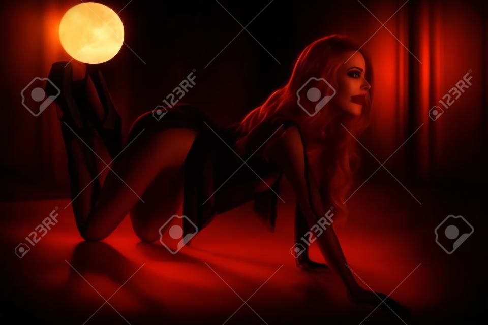 Ritratto di giovane donna sexy in stile bdsm nell'interiore di notte oscura