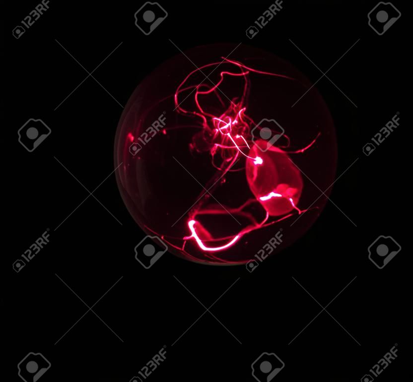 Energy from red laser beams forms a chaotic swirl within a crystal sphere.
