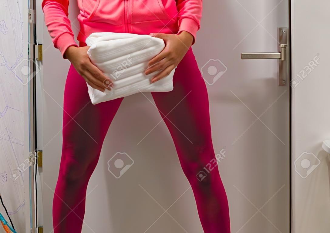 Urine-incontinentie, Jonge dame in een natte legging met een witte volwassen luier, Beschamende gezondheidsproblemen