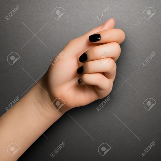 Woman hand showing picking up pose or holding something with two fingers on black background. Isolated with clipping path.