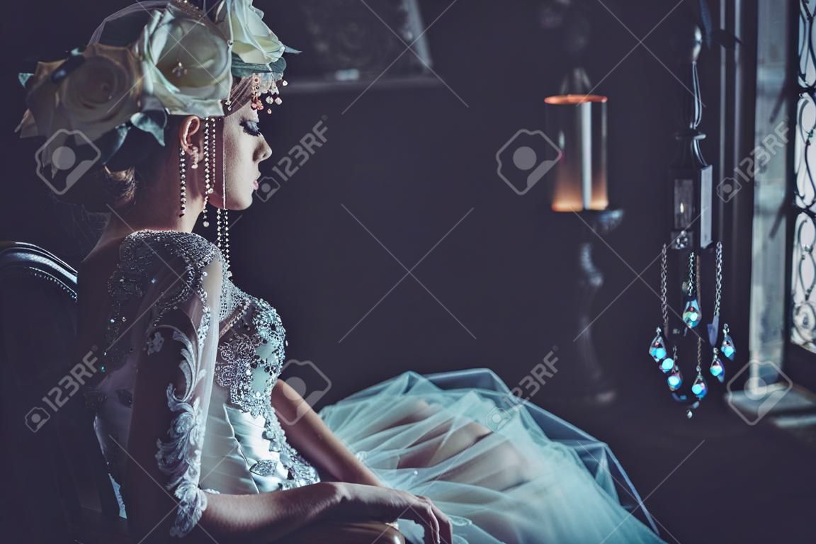 Schöne Braut sitzt auf einem Stuhl. Luxuspalast