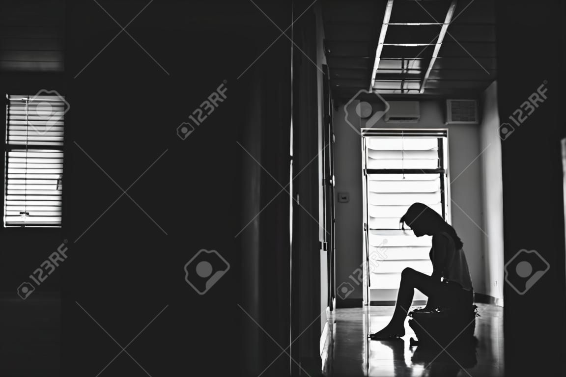 Silhouette of girl sitting alone in the dark,Sad and Serious women sitting hug his knee alone of old condo, Domestic violence, family problems, Stress, violence, The concept of depression and suicide
with copy space